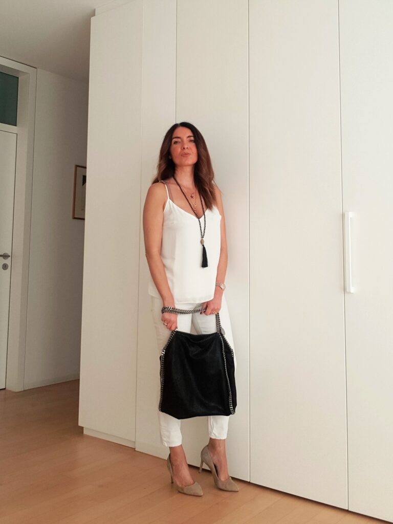 Outfit primavera estate in bianco con accessori neri e borsa Falabella di Stella Mc Cartney